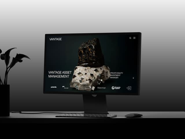 A computer monitor displays the Vantage Asset Management website homepage featuring a mineral sculpture and partner logos.