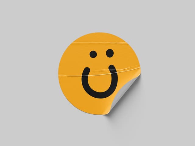 A round orange sticker with a smiling face peels up at the corner.