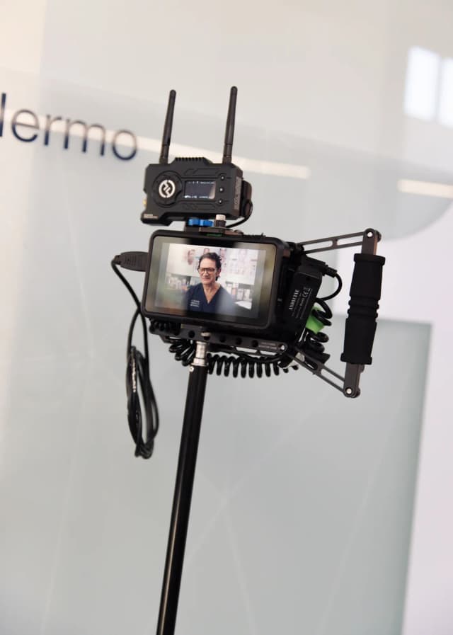 Director’s monitor showing a framed talking-head subject during recording, with the camera’s timecode and exposure overlay visible.