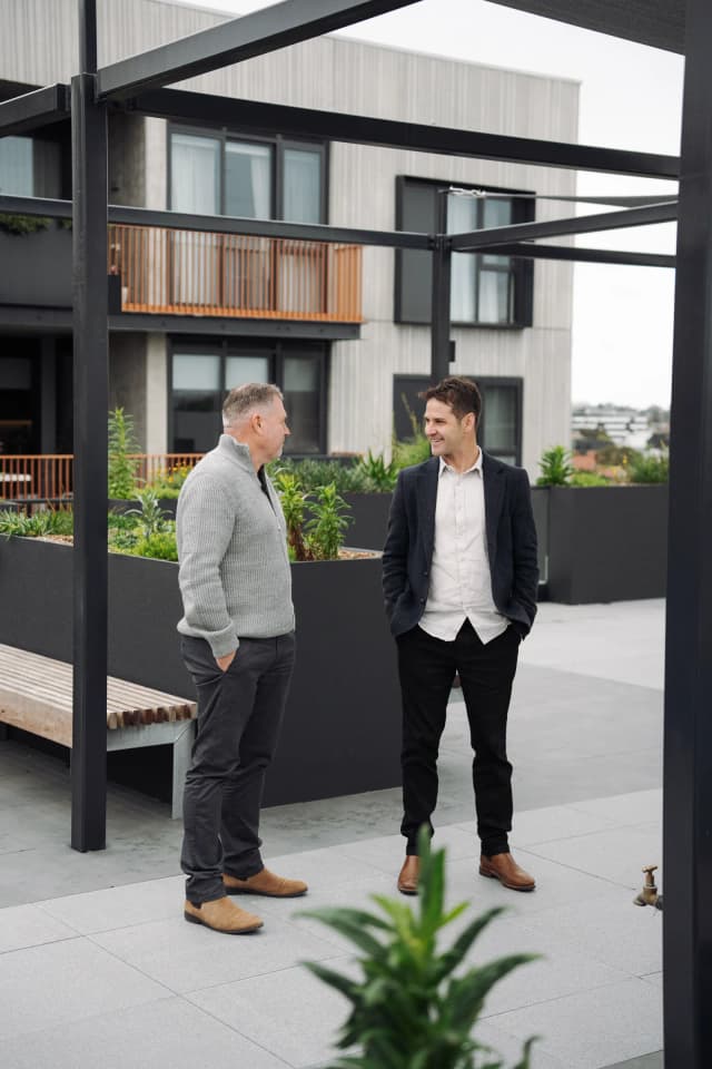 Two people talking under the rooftop pergola at East Brunswick Village