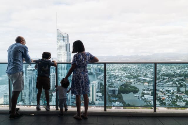 A family looks out over the Gold Coast skyline from a balcony at Hilton Surfers Paradise.