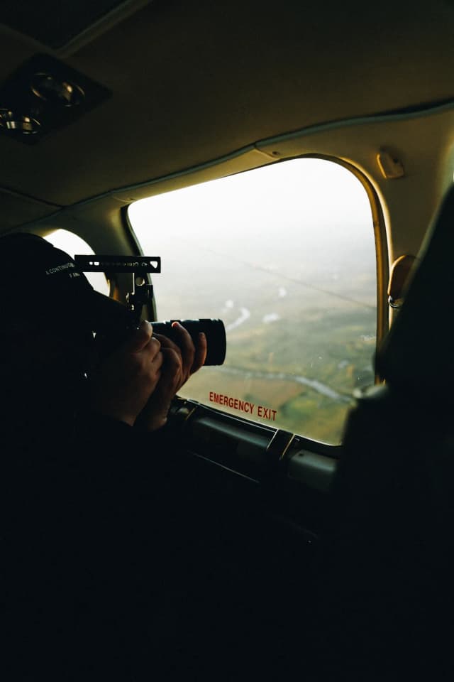 A Lucky Boy operator shooting out of the window of a light plane on the way to Moree