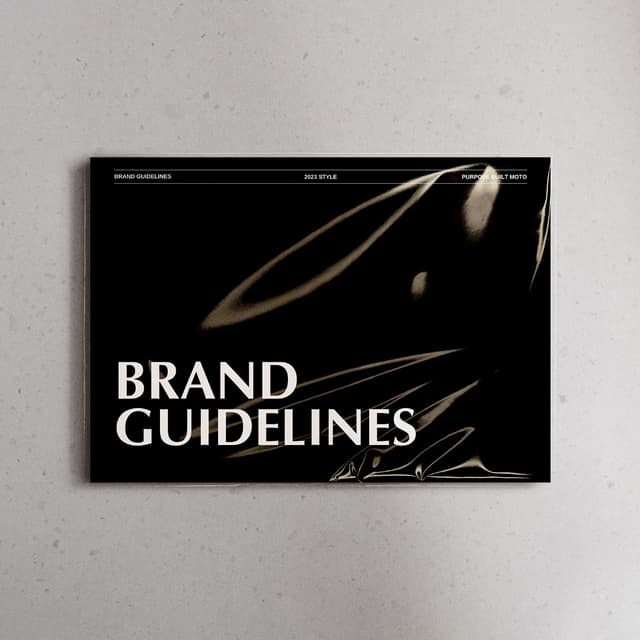 A brand guidelines book mockup with a dark abstract cover for Purpose Built Moto.