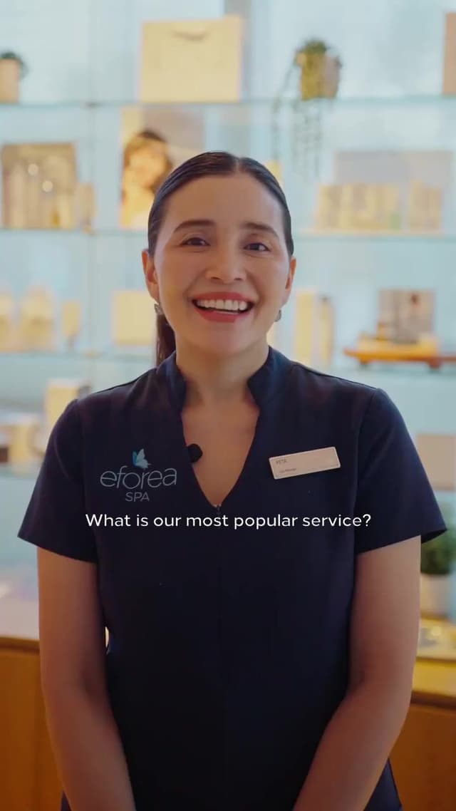 An eforea Spa staff member smiles on camera in front of shelves of skincare products, answering a question about services.
