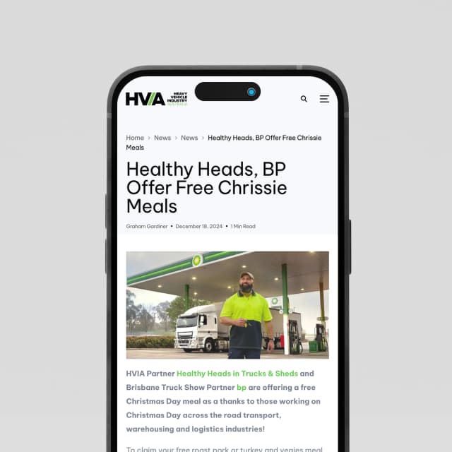 A phone mockup shows the Heavy Vehicle Industry Australia website displaying a news article about free Christmas meals for truckies.
