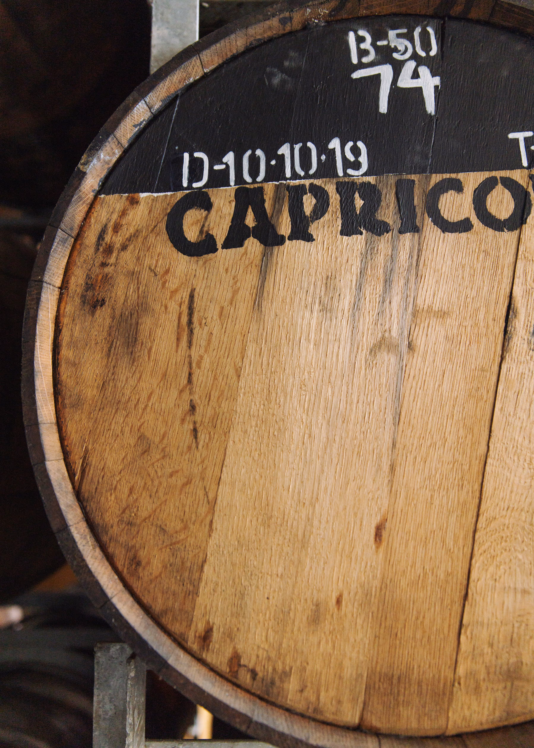 A Capricorn Distilling Co whiskey barrel head stamped with a batch number and fill date.