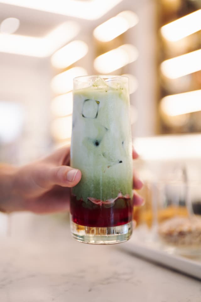 A layered matcha drink held up at the Hilton Surfers Paradise bar