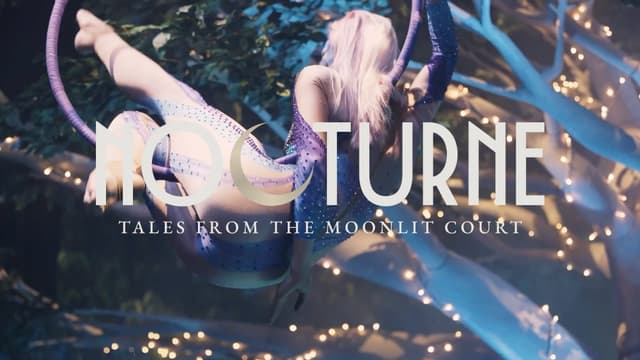 An aerial dancer performs on a hoop among fairy lit trees for Nocturne, tales from the moonlit court.