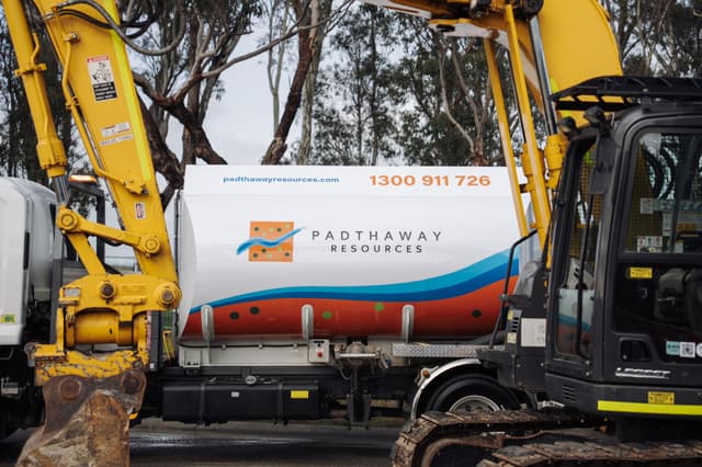 A Padthaway Resources tanker in the new livery, parked between two excavators on a civil site.