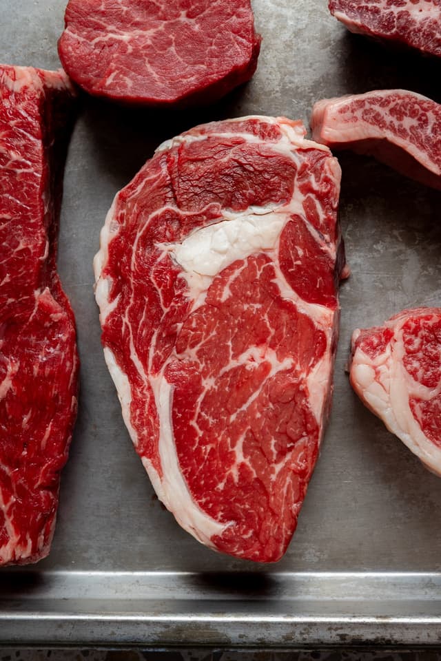 For Providore Global, raw marbled beef cuts including fillet and ribeye are laid out on a steel tray.