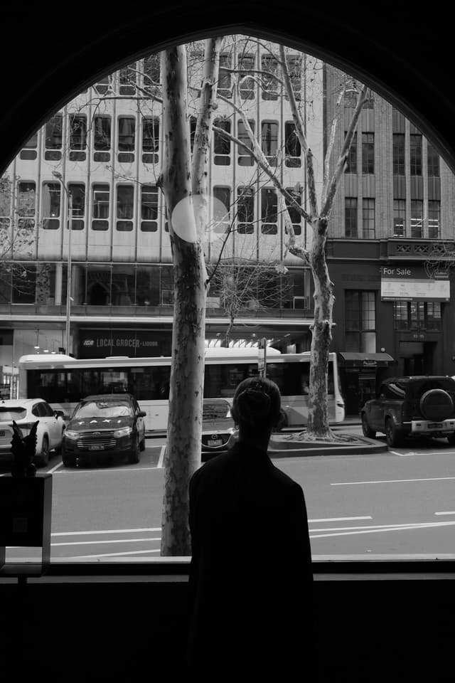 From a Vantage Asset Management office window, an arched view overlooks a Melbourne CBD street with taxis and a tram.