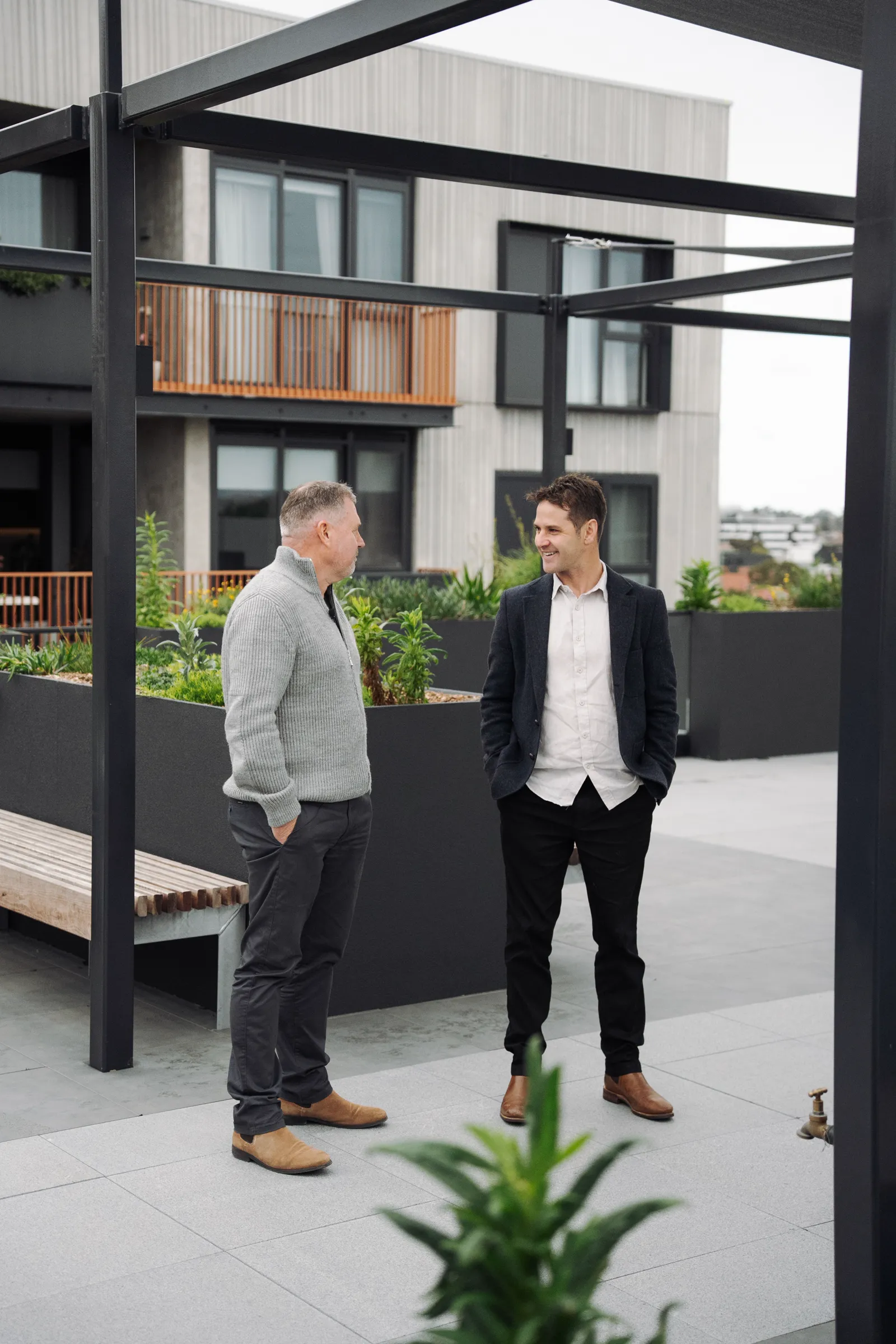 Two people talking under the rooftop pergola at East Brunswick Village