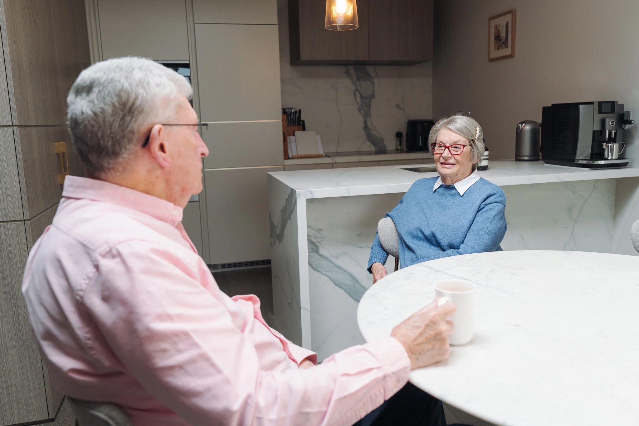 Tim talking with Diana across the table in their apartment at Robin Syme