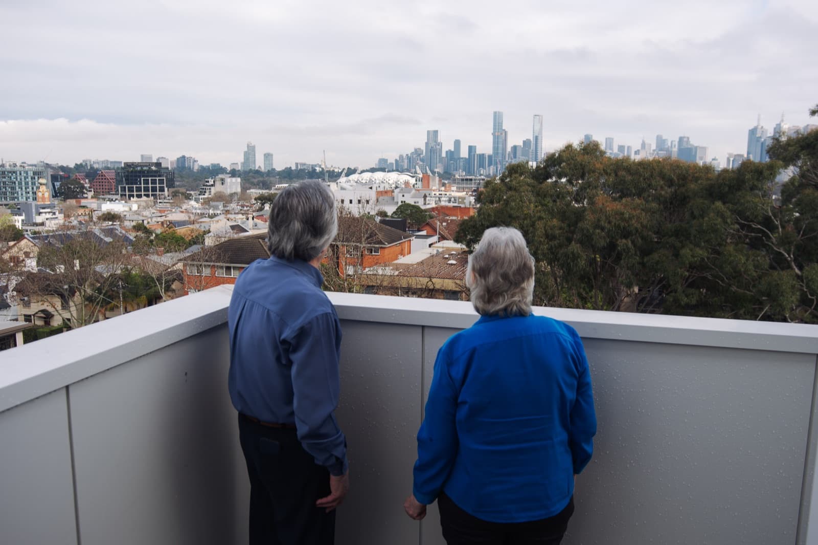 Savas and Georgia on the balcony at John Hood Terrace, looking out over Richmond to the Melbourne skyline