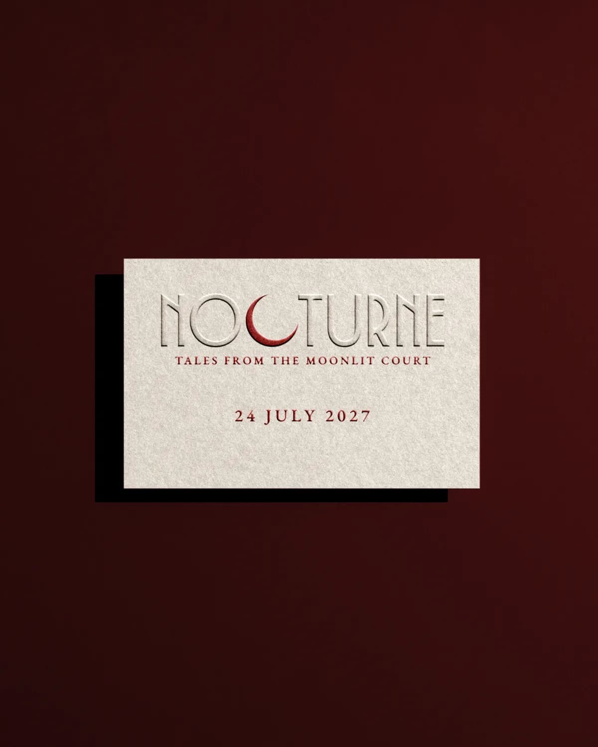 The Nocturne invitation card, blind embossed on bone stock with the crescent in accent red.