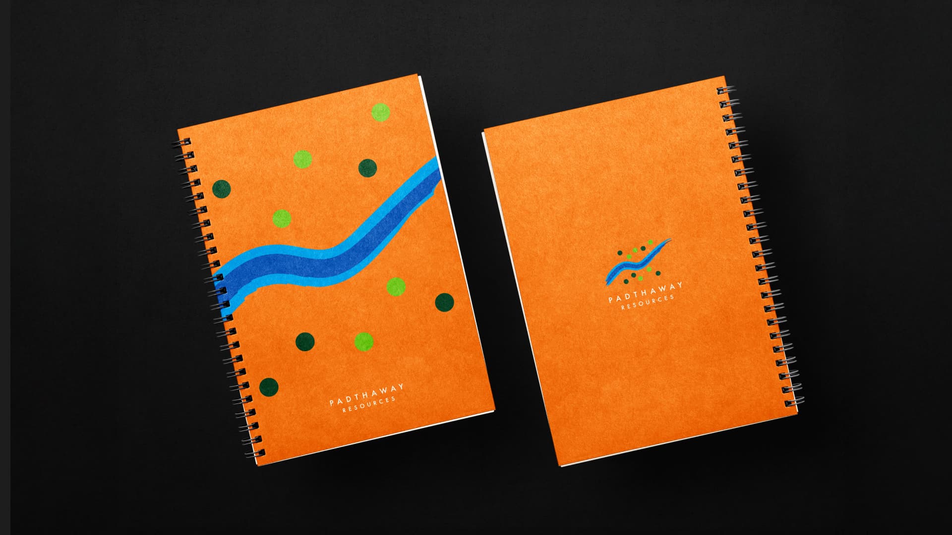 Padthaway notebooks in Harvest Orange, one cover carrying the river motif and one the stacked mark.