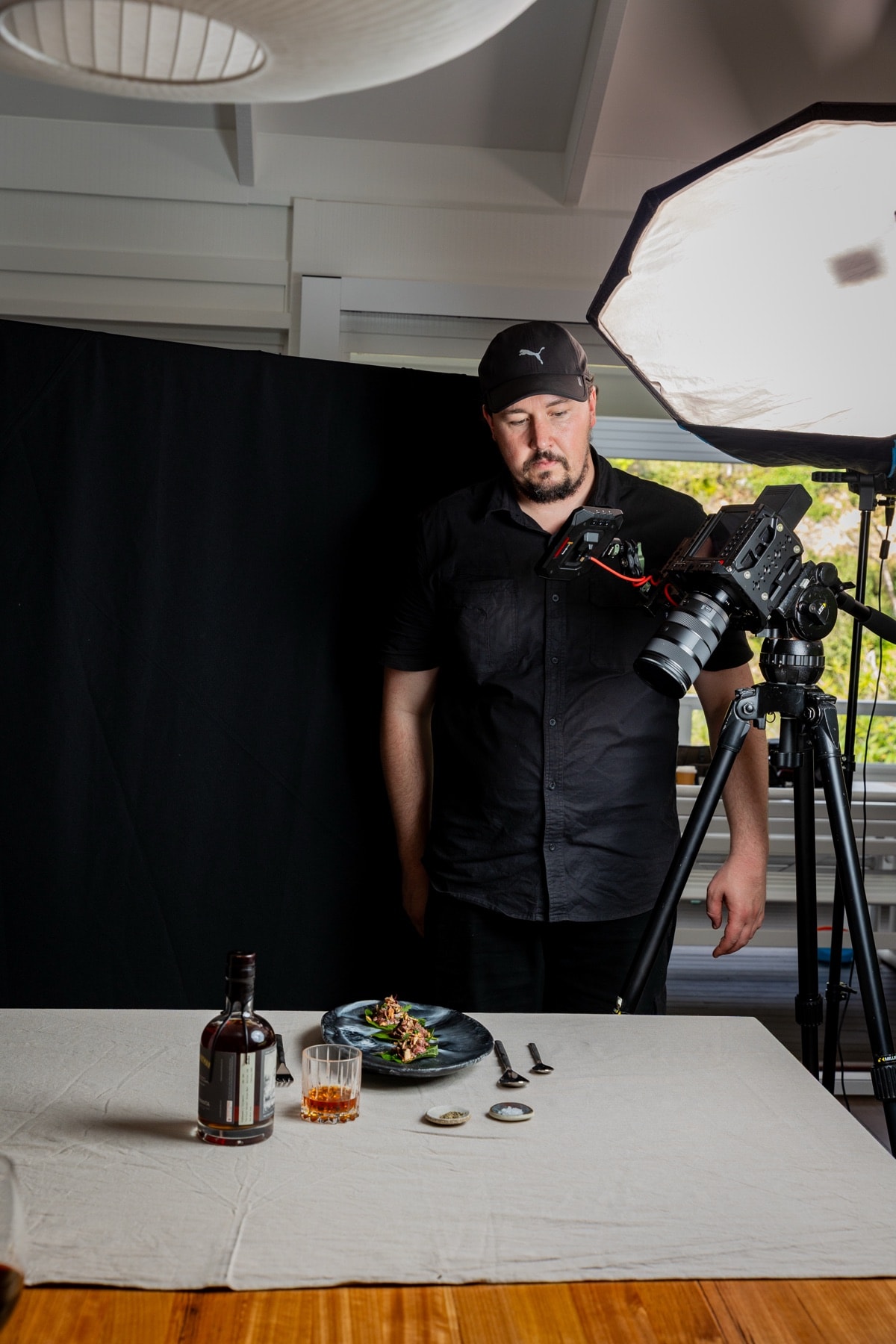 Behind the scenes on the Providore Global shoot in Byron Bay, photographer composing a plated dish under a softbox.